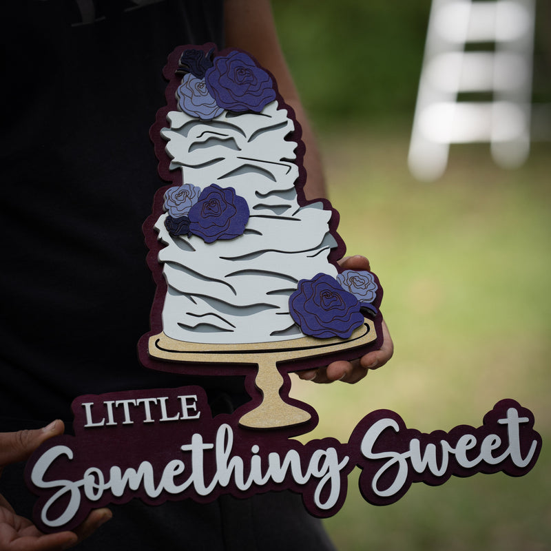 Andrey from WoodHarmonyUS holding a multi-layered 3D wood sign shaped like a cake for "Little Something Sweet". Personalized bakery signage in Tampa.