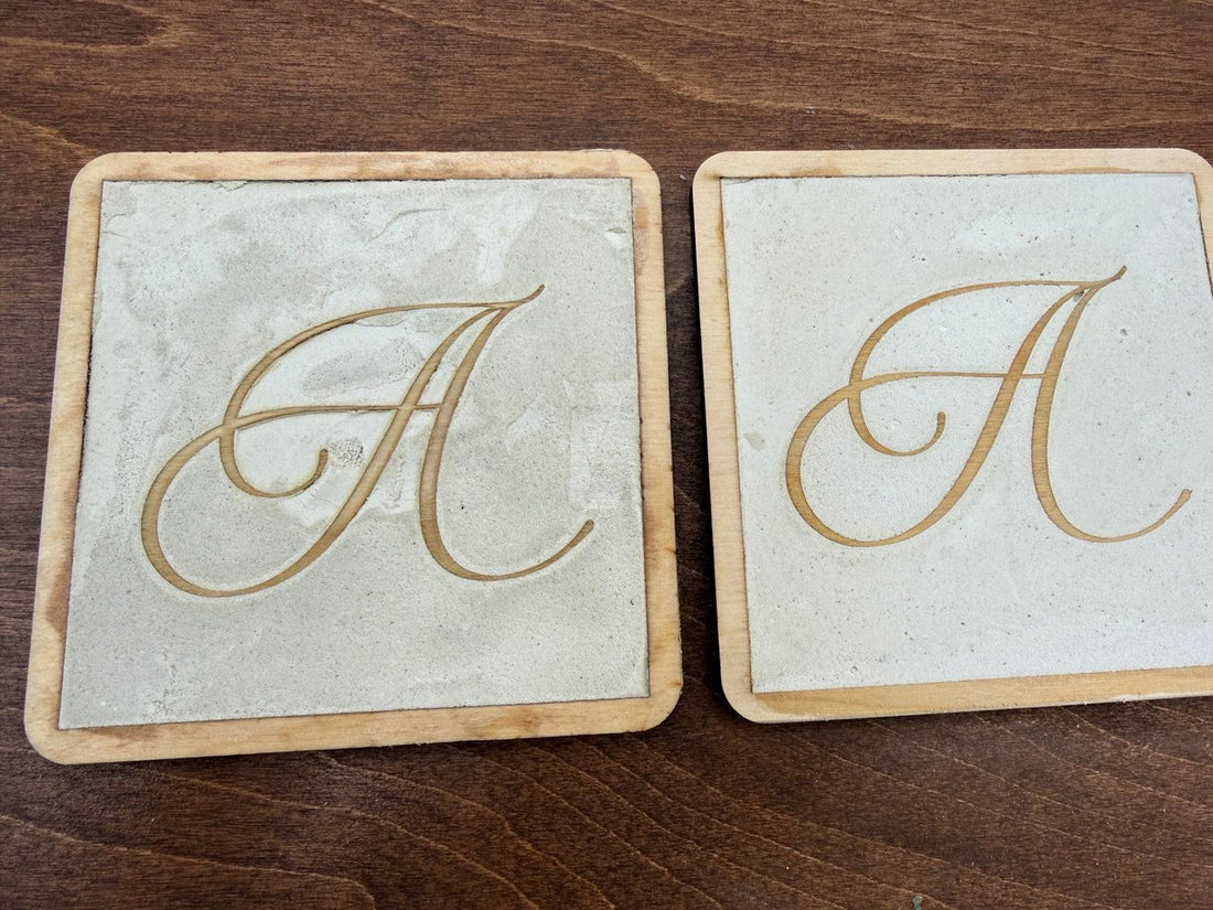 Wood and microcement coaster samples with laser-cut calligraphy design showing texture contrast for modern business signage experiments