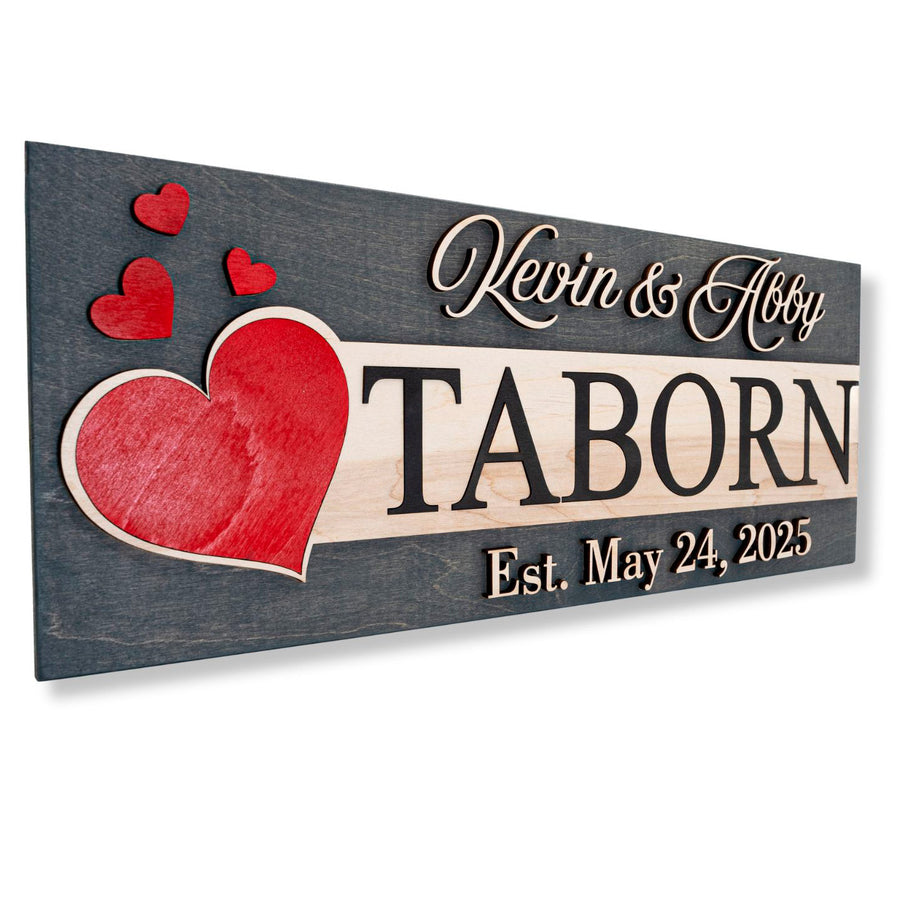 Grey wood sign with a large red layered heart, reading Kevin & Abby, TABORN, Est. May 24, 2025.