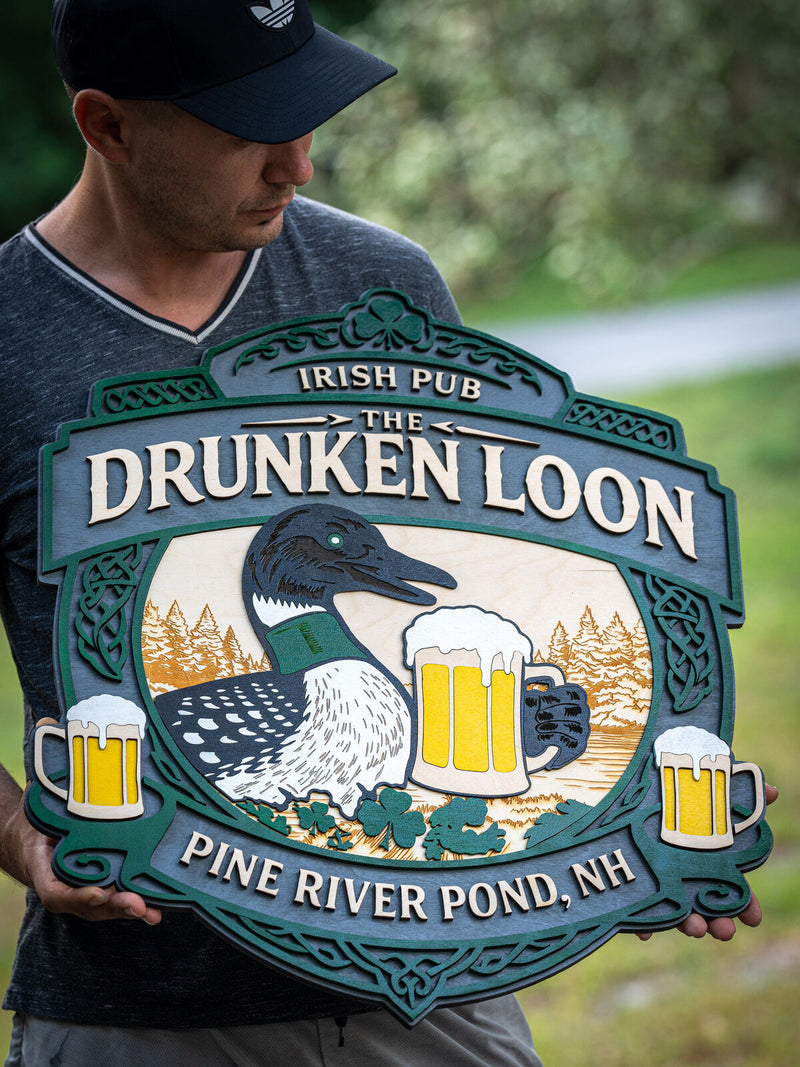 Large ornate green and slate wood Irish pub sign for The Drunken Loon with Celtic knotwork borders, a loon on a lake and three beer steins
