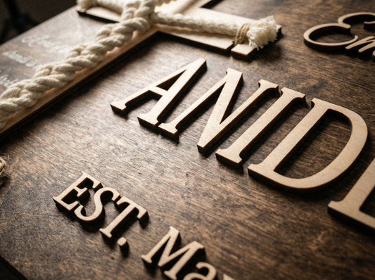 Close-up of raised white 3D lettering on a cord of three strands wedding sign