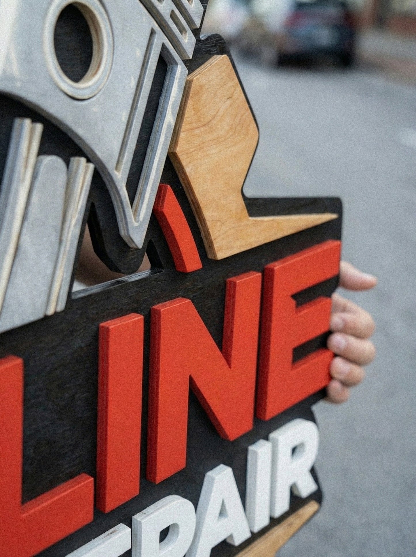Close-up of multilayered 3D wood business sign, laser cut painted wooden logo with premium finish for reception wall.