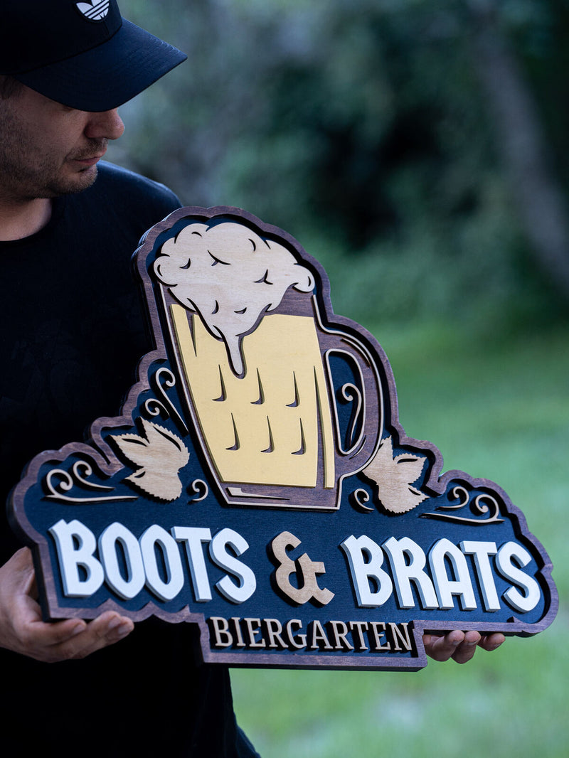 Navy shaped wood biergarten sign with a tall cream and yellow beer stein overflowing with foam, flanked by white edelweiss flowers