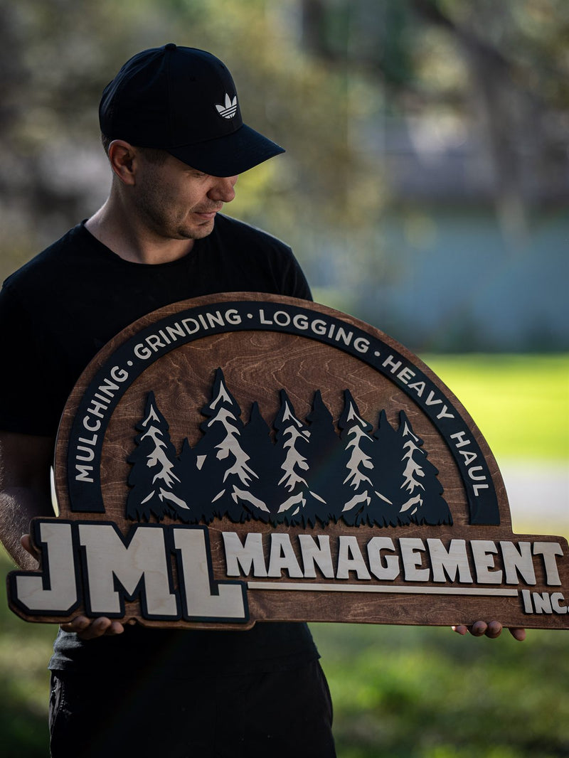 Arch-topped wood contractor sign for JML Management with layered charcoal and cream pines and services around the arc
