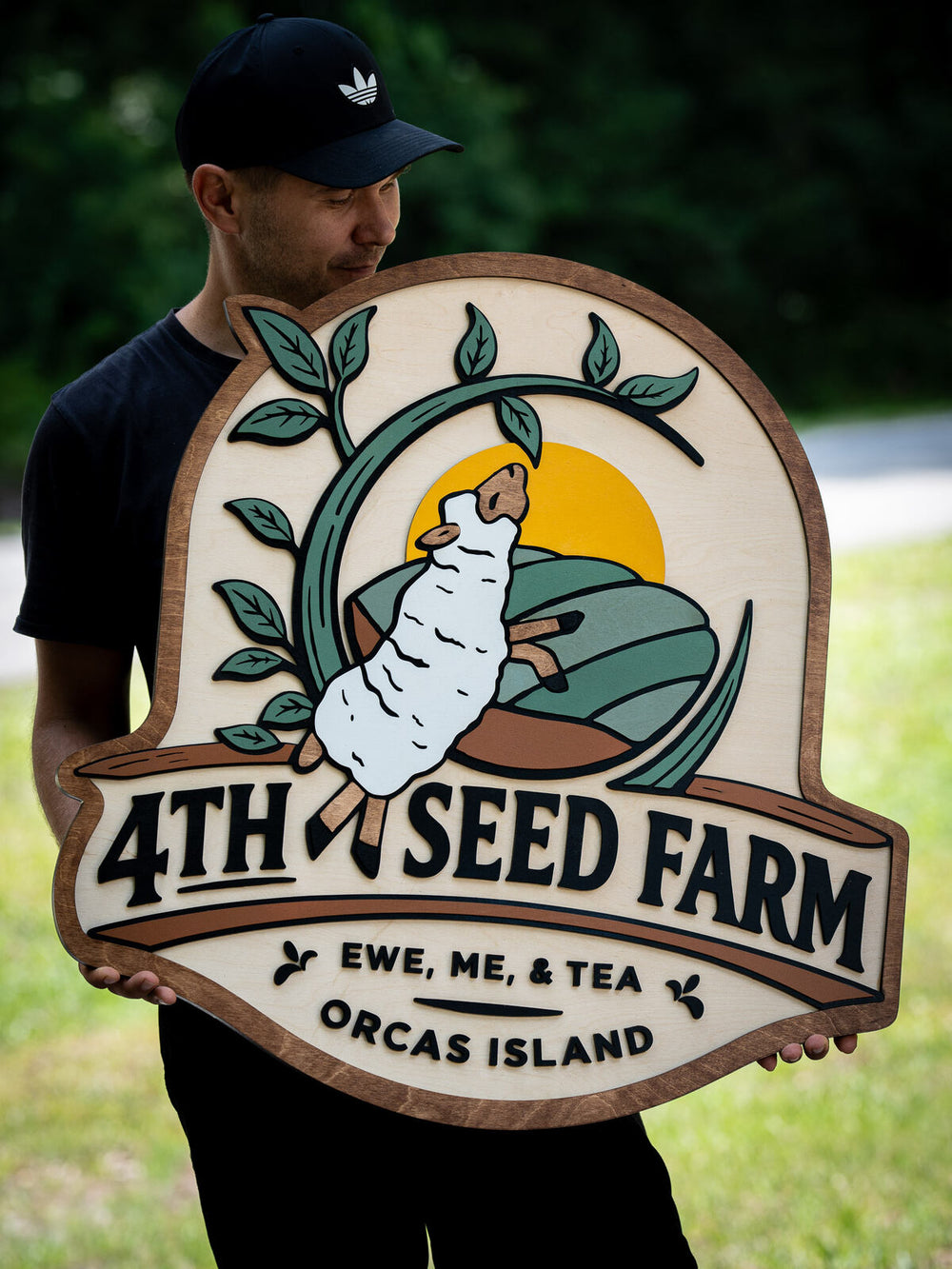 Finished premium Baltic birch 3D wood business sign ready to hang, held by the maker