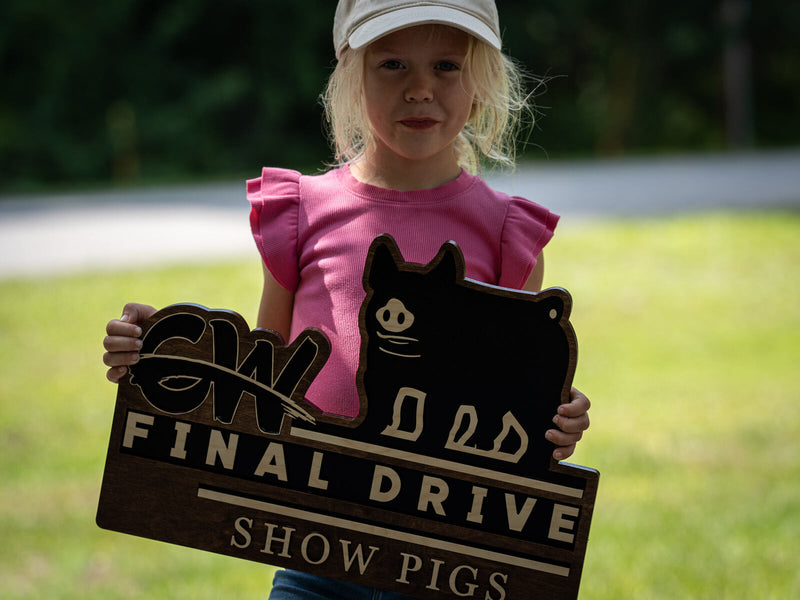 Shaped dark walnut livestock sign with a large black pig silhouette and a script CW monogram, reading Final Drive Show Pigs