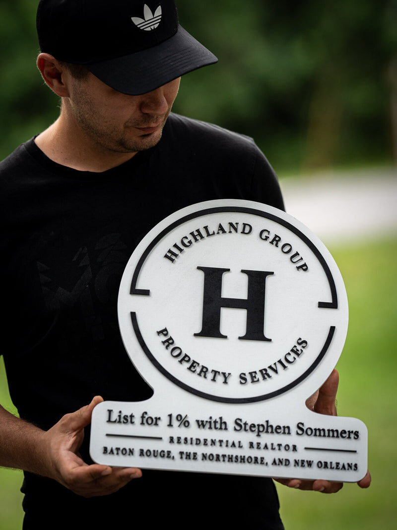 Crisp white circular real estate sign with a rider panel, a bold black H inside a broken ring, reading Highland Group Property Services